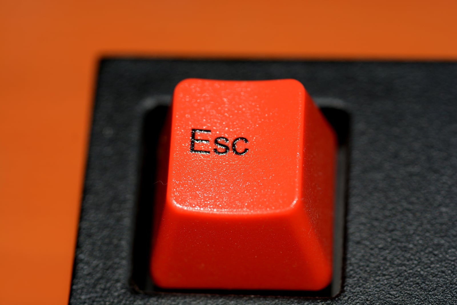 Archive photograph of a red Escape key on a black computer keyboard.