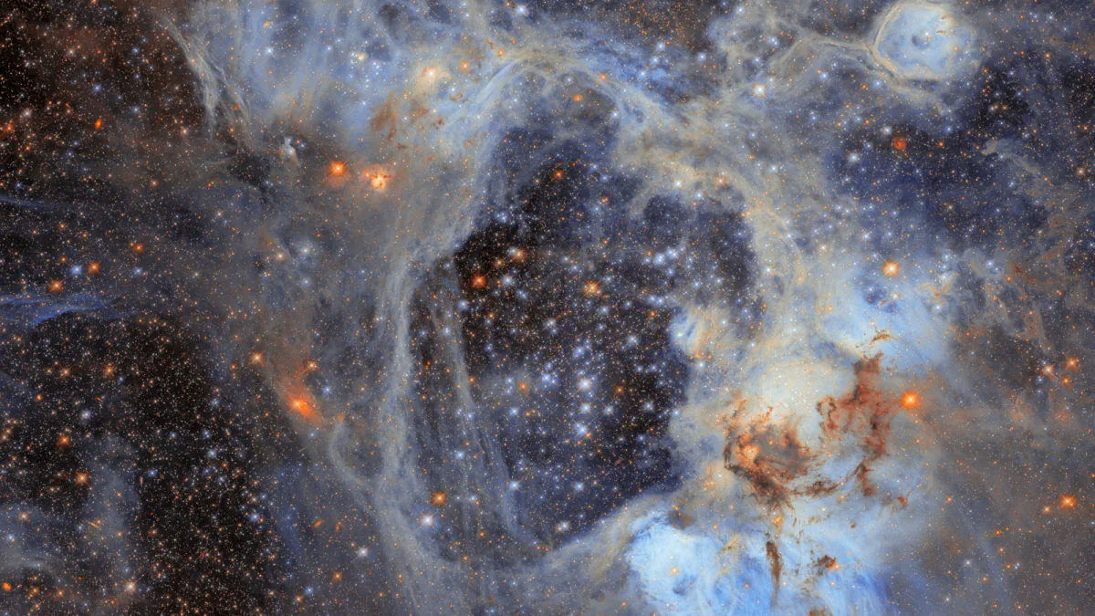 A dense field of blue, white and orange stars surrounded by pale glowing gas and dark dust in the N44 nebula.