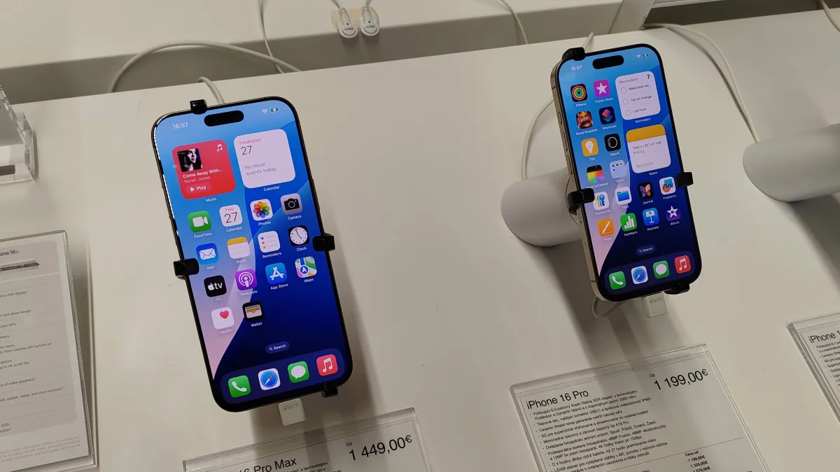 Two iPhone 16 Pro-series display phones on a retail counter, with their home screens visible.
