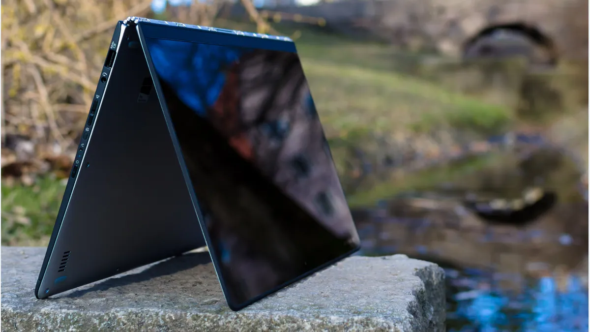 A 2015 Lenovo Yoga 3 Pro standing in tent mode on an outdoor stone ledge.