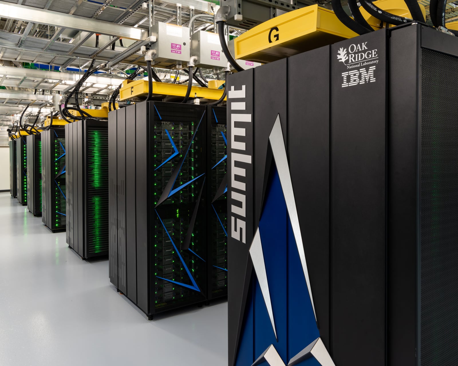 Archive photograph of the Summit supercomputer’s rows of cabinets at Oak Ridge National Laboratory.