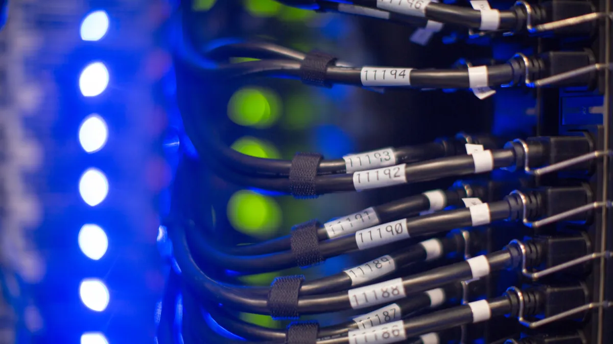 Network cables connect to equipment beside rows of blue and green indicator lights.